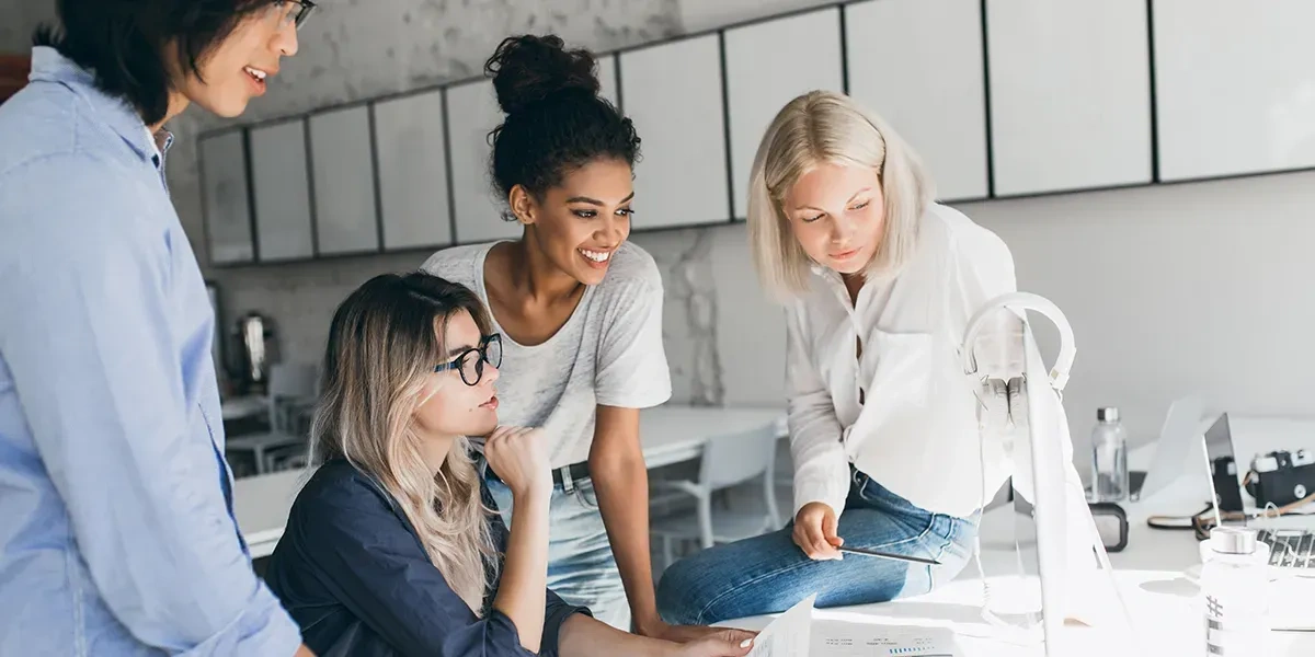 conjunto de mujeres trabajando cooperativamente en un ordenador