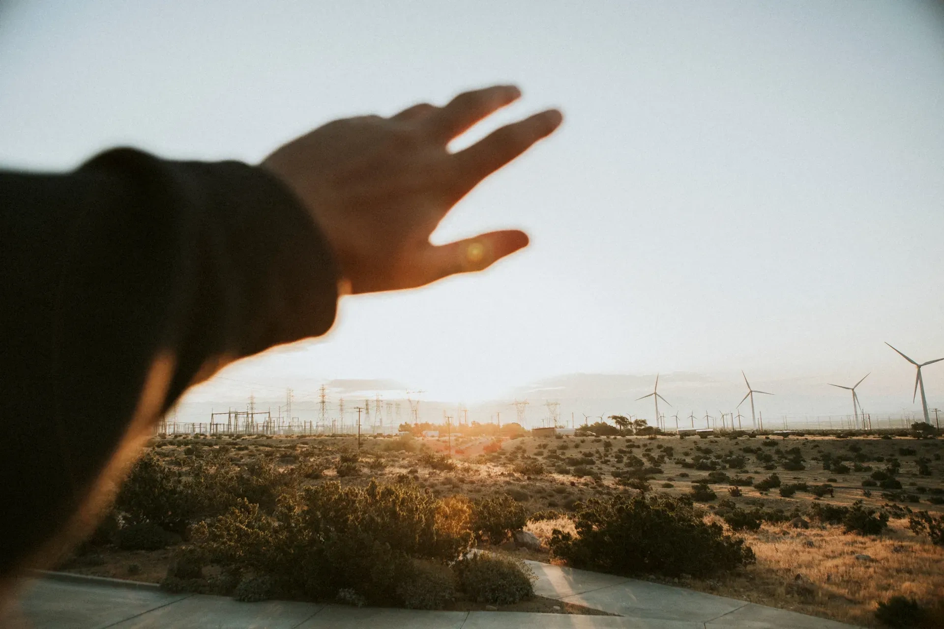Paisaje con turbinas eólicas al atardecer, simbolizando la transición hacia energías renovables con seguridad energética y la lucha contra el cambio climático