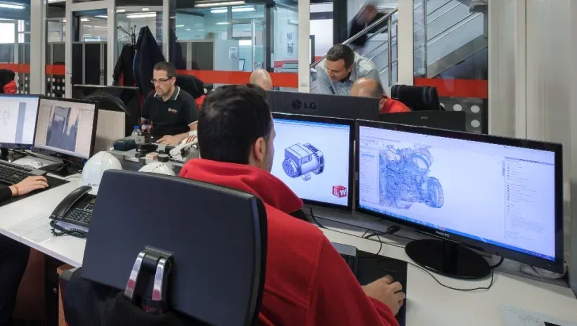 Ingenieros trabajando en el diseño de componentes en 3D, aplicando tecnología de fabricación aditiva