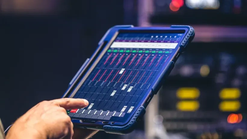 Técnico revisando en una tablet los parámetros de carga para calcular la potencia en kVA necesaria en un grupo electrógeno.