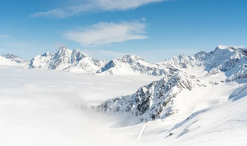 Paisaje de montañas nevadas que ilustra los desafíos de operar grupos electrógenos en climas fríos, donde las bajas temperaturas pueden afectar el arranque y la eficiencia del motor.